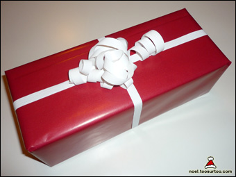 Cadeau emballé avec du papier rouge et du ruban blanc